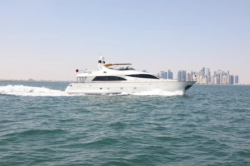  Yacht Photos Pics Luxury Falcon 90 yacht cruising on open water, city skyline in background, 2005 model.