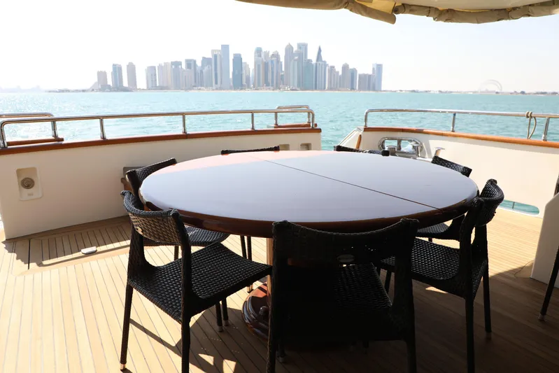  Yacht Photos Pics Luxury yacht deck with round table, city skyline view; Falcon 90, 2005 model.