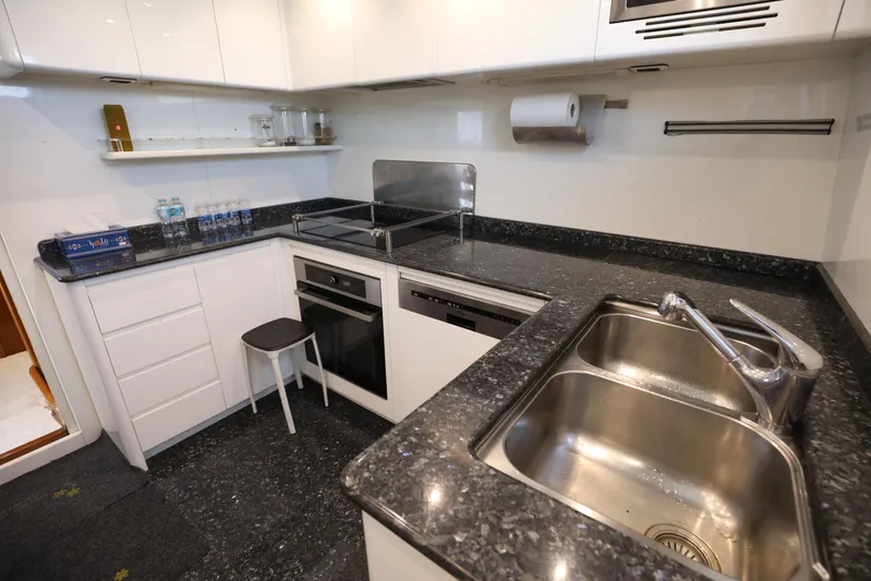  Yacht Photos Pics Modern kitchen with granite countertops, stainless steel sink, and white cabinetry in a Falcon 90 yacht.