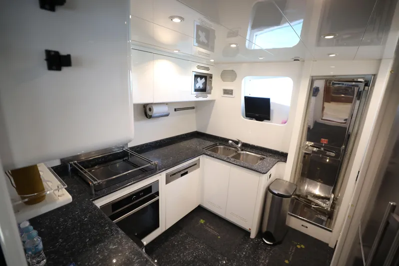  Yacht Photos Pics Modern kitchen interior in a 2005 Falcon 90 yacht, featuring sleek countertops and appliances.