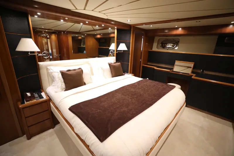  Yacht Photos Pics Luxurious bedroom interior of 2005 Falcon 90 yacht with elegant wood finishes and cozy bedding.