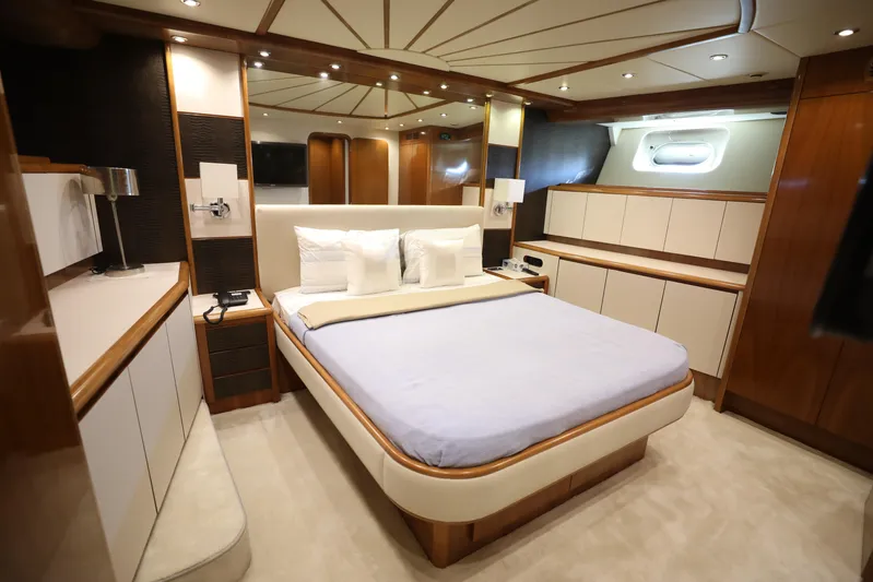  Yacht Photos Pics Luxurious bedroom interior of a 2005 Falcon 90 yacht, featuring elegant wood finishes.