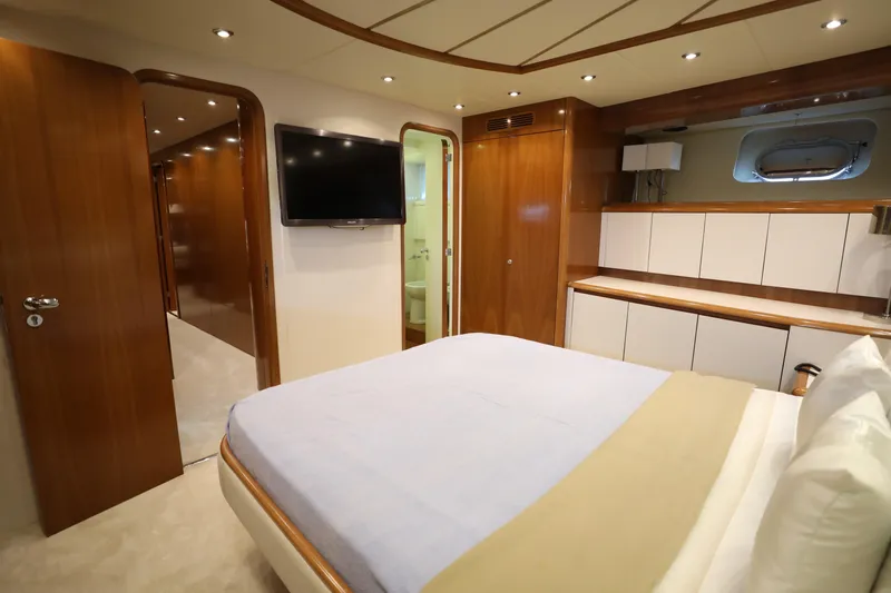  Yacht Photos Pics Luxurious bedroom interior of 2005 Falcon 90 yacht with modern amenities and elegant wood finishes.