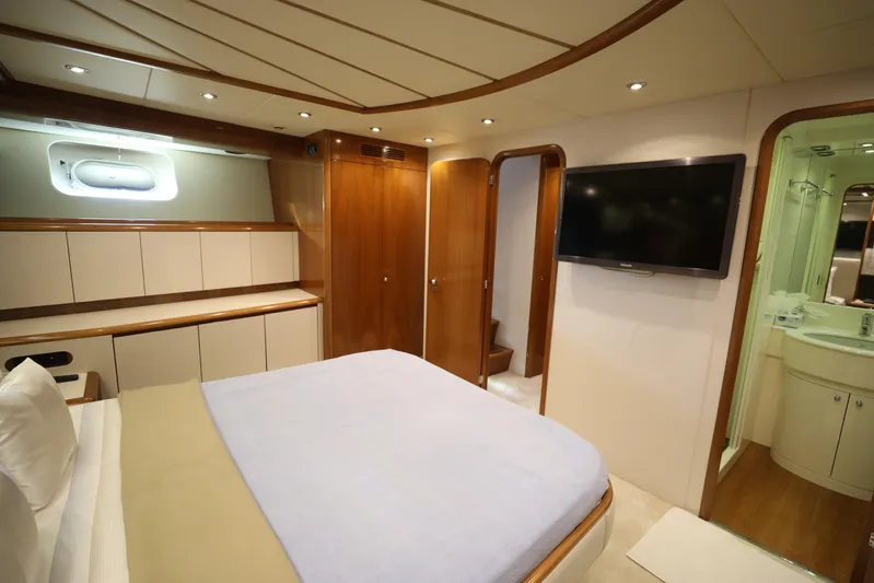  Yacht Photos Pics Luxurious cabin interior of 2005 Falcon 90 yacht with bed, TV, and ensuite bathroom.