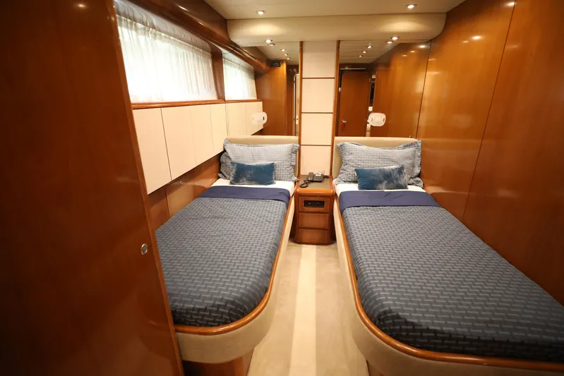  Yacht Photos Pics Luxurious twin cabin in 2005 Falcon 90 yacht with wood paneling and blue bedding.