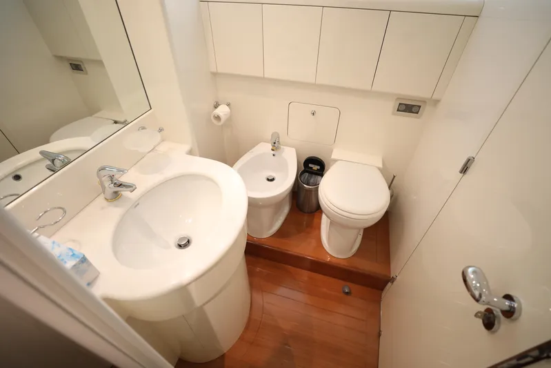  Yacht Photos Pics Compact yacht bathroom with sink, toilet, and bidet on wooden flooring, Falcon 90, 2005 model.