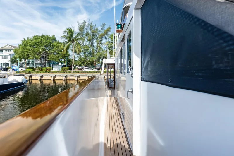 El Legado Yacht Photos Pics Side deck view of 2005 Grand Banks 72 Aleutian RP yacht docked by palm trees.