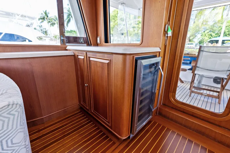 El Legado Yacht Photos Pics Luxurious interior of 2005 Grand Banks 72 Aleutian RP yacht with wooden cabinetry and wine cooler.