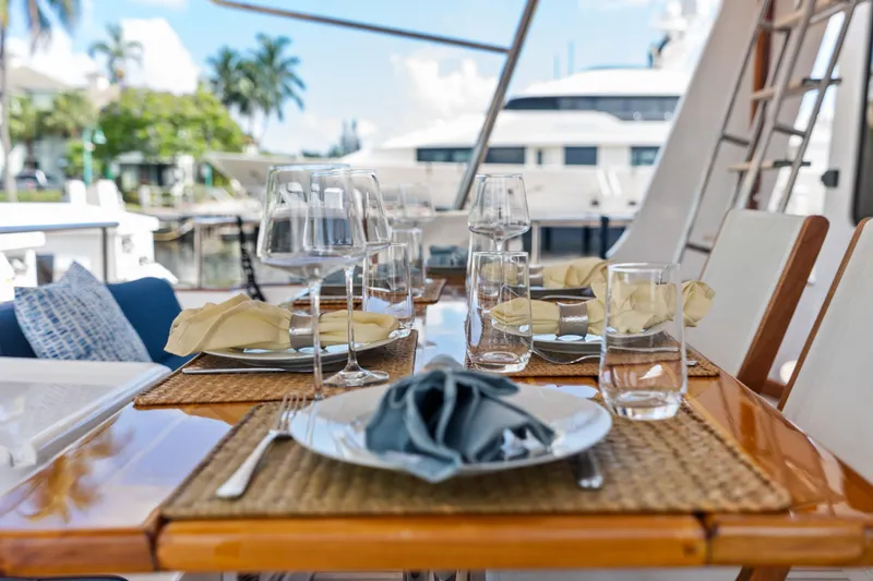 El Legado Yacht Photos Pics Elegant dining setup on 2005 Grand Banks 72 Aleutian RP yacht, featuring glassware and napkins.