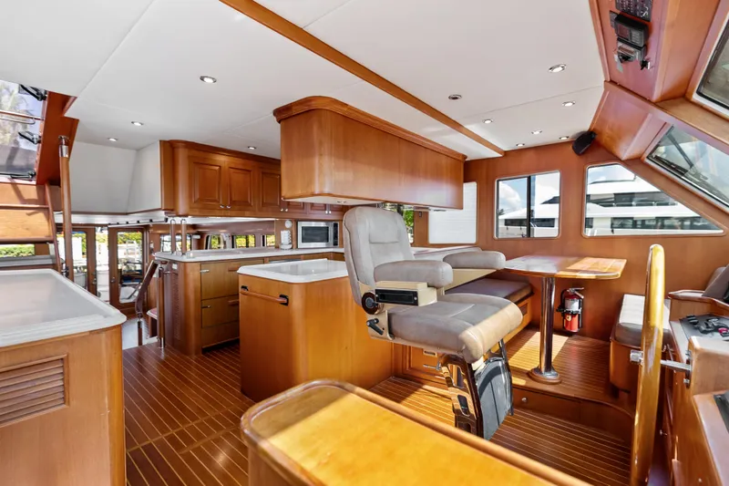 El Legado Yacht Photos Pics Luxurious interior of 2005 Grand Banks 72 Aleutian RP yacht with wood finishes and helm station.