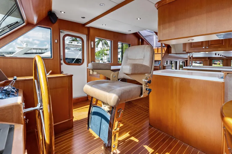 El Legado Yacht Photos Pics Luxurious interior of 2005 Grand Banks 72 Aleutian RP yacht with wooden helm and seating.