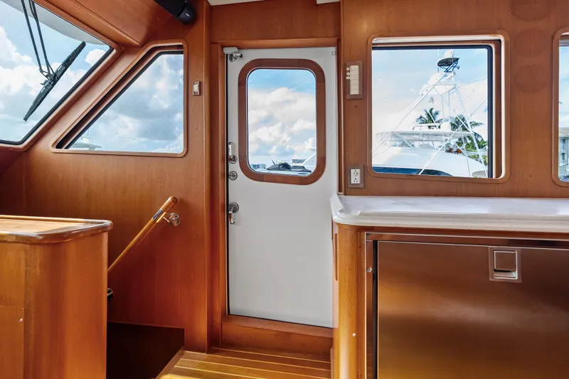 El Legado Yacht Photos Pics Interior of 2005 Grand Banks 72 Aleutian RP yacht with wooden finishes and windows.