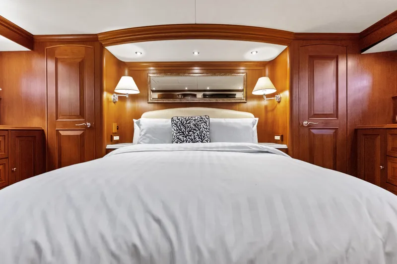 El Legado Yacht Photos Pics Luxurious bedroom interior of 2005 Grand Banks 72 Aleutian RP yacht with elegant wood paneling.