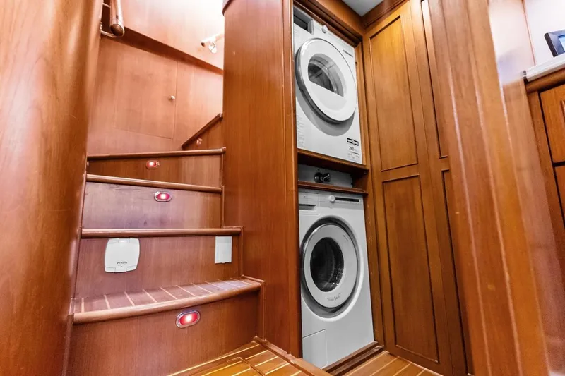 El Legado Yacht Photos Pics Laundry area on 2005 Grand Banks 72 Aleutian RP yacht with wooden stairs and cabinetry.