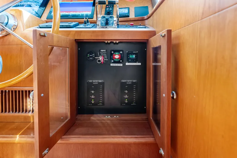 El Legado Yacht Photos Pics Control panel inside a 2005 Grand Banks 72 Aleutian RP yacht, featuring wooden cabinetry.