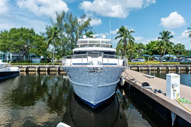 El Legado Yacht Photos Pics 2005 Grand Banks 72 Aleutian RP yacht docked, surrounded by palm trees and blue sky.