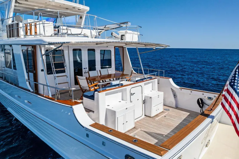 El Legado Yacht Photos Pics 2005 Grand Banks 72 Aleutian RP yacht on open sea, featuring spacious deck and American flag.