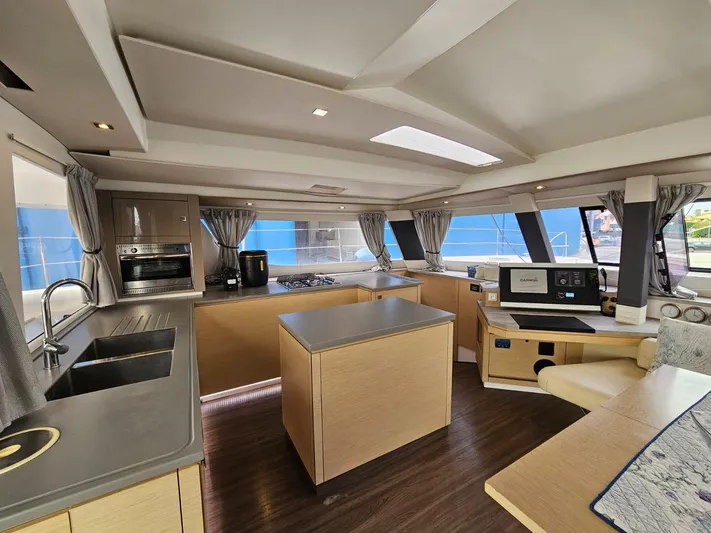  Yacht Photos Pics Luxurious interior of 2016 Fountaine Pajot SABA 50 catamaran with modern kitchen and seating area.
