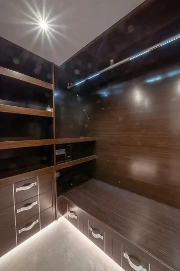  Yacht Photos Pics Modern walk-in closet with dark wood shelves and LED lighting, Pearl 95, 2020 model.