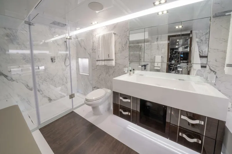  Yacht Photos Pics Luxurious modern bathroom with marble walls, glass shower, and sleek vanity in Pearl 95 yacht.