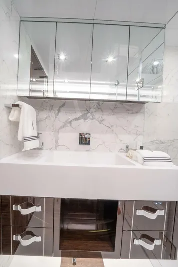 Yacht Photos Pics Modern bathroom with marble walls, mirrored cabinets, and sleek fixtures in a Pearl 95 yacht, 2020 model.