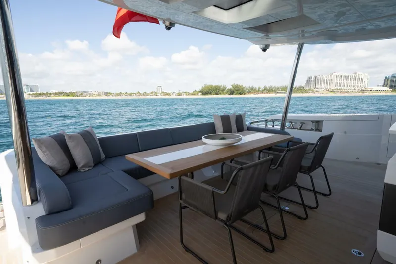  Yacht Photos Pics Luxurious Pearl 95 yacht deck with seating and dining area, overlooking serene ocean view.