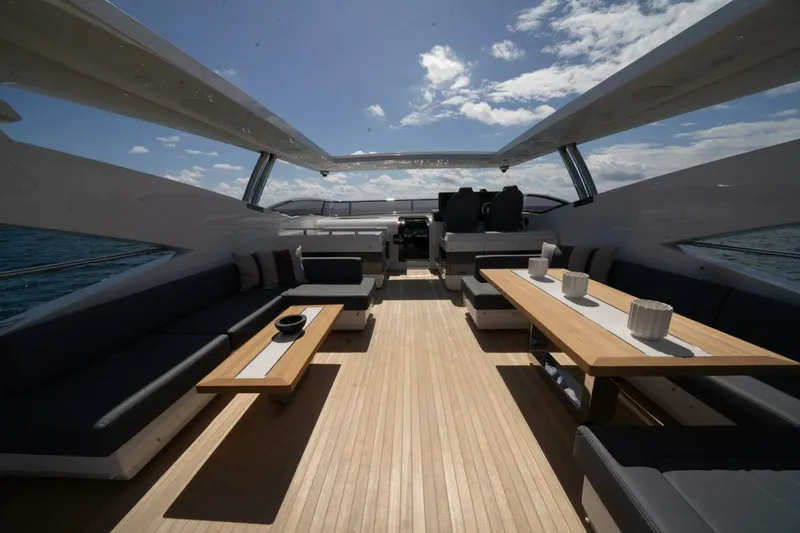  Yacht Photos Pics Luxurious 2020 Pearl 95 yacht interior with elegant seating and wooden tables under a clear sky.