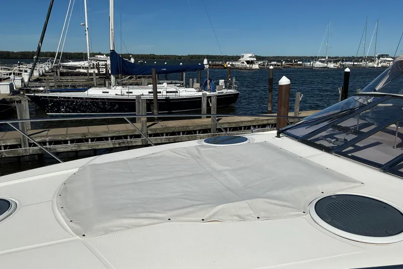 Knee Deep Yacht Photos Pics 2003 Regal Commodore 4260 yacht docked at marina, clear blue sky, calm waters.