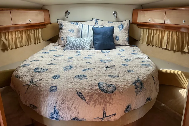 Knee Deep Yacht Photos Pics Luxurious 2003 Regal Commodore 4260 yacht bedroom with nautical-themed bedding.