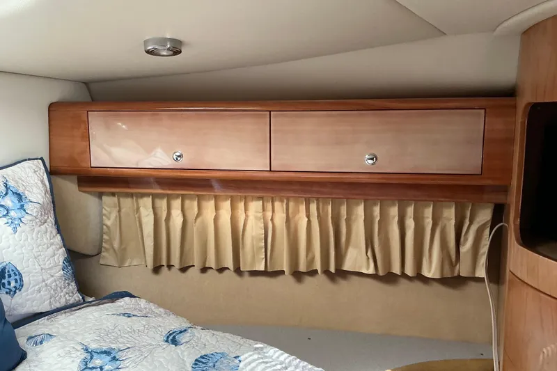 Knee Deep Yacht Photos Pics 2003 Regal Commodore 4260 cabin interior with wooden cabinets and floral bedding.