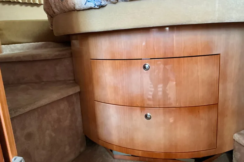 Knee Deep Yacht Photos Pics 2003 Regal Commodore 4260 interior with wooden drawers and carpeted steps.