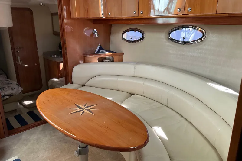 Knee Deep Yacht Photos Pics Luxurious interior of 2003 Regal Commodore 4260 yacht with elegant seating and wooden table.