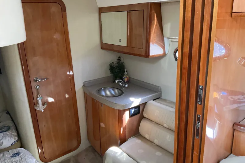 Knee Deep Yacht Photos Pics 2003 Regal Commodore 4260 yacht interior with wooden cabinetry and compact sink area.