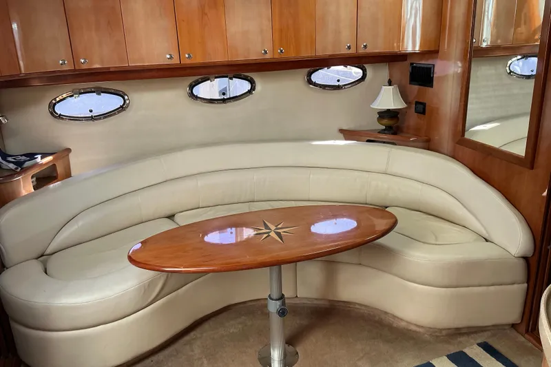 Knee Deep Yacht Photos Pics Luxurious interior of 2003 Regal Commodore 4260 yacht with curved seating and elegant table.