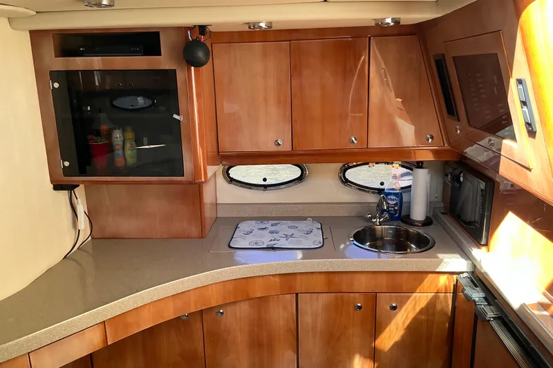 Knee Deep Yacht Photos Pics 2003 Regal Commodore 4260 yacht kitchen with wooden cabinets and modern amenities.