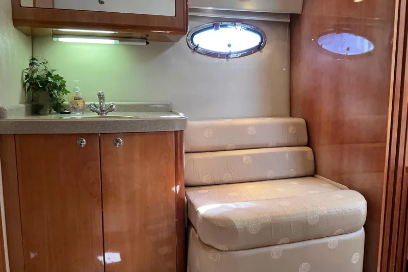 Knee Deep Yacht Photos Pics 2003 Regal Commodore 4260 yacht interior with sink, seating, and porthole window.