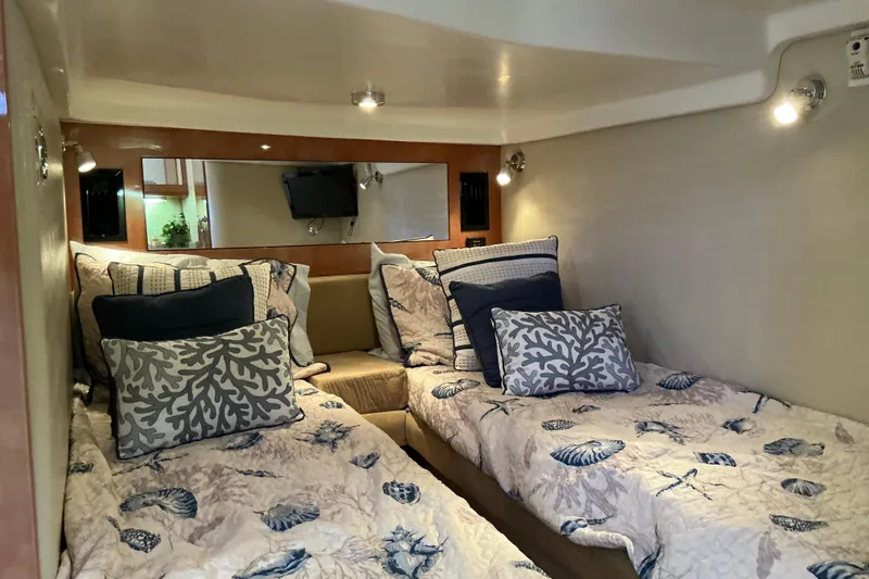 Knee Deep Yacht Photos Pics 2003 Regal Commodore 4260 cabin with twin beds, nautical-themed bedding, and cozy lighting.