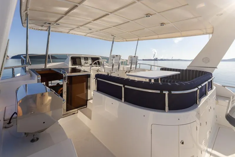 Raindancer Yacht Photos Pics 2009 Selene 60 Ocean Trawler yacht deck with seating and helm, overlooking calm waters.