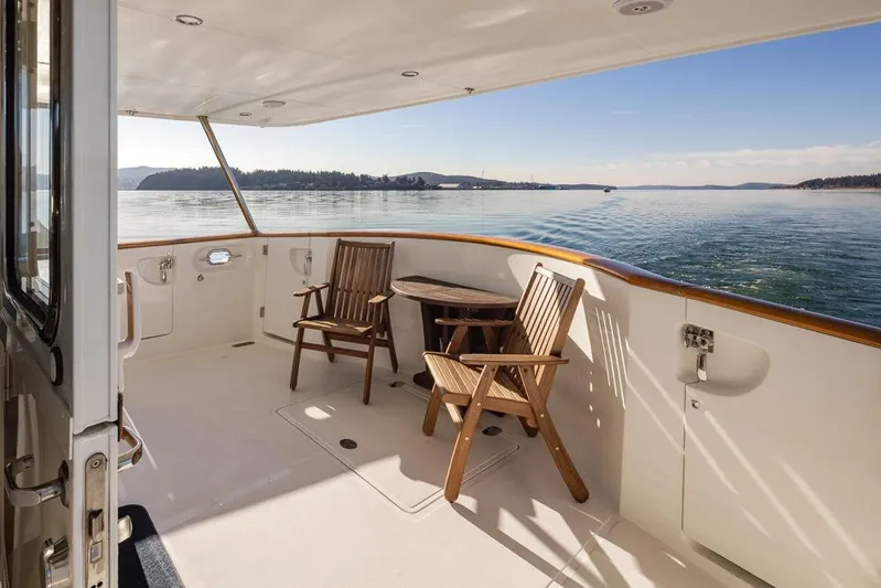 Raindancer Yacht Photos Pics 2009 Selene 60 Ocean Trawler deck with wooden chairs, scenic ocean view.