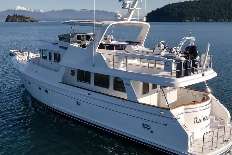 Raindancer Yacht Photos Pics 2009 Selene 60 Ocean Trawler yacht cruising on serene waters with scenic mountain backdrop.