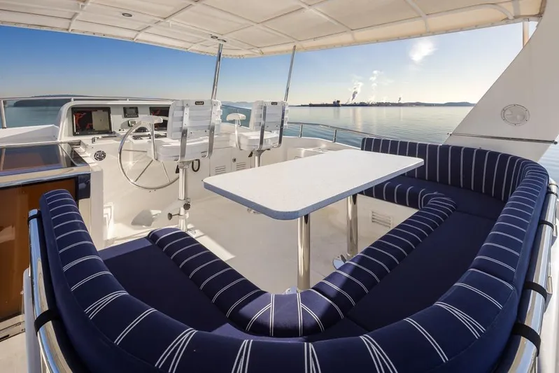 Raindancer Yacht Photos Pics Flybridge of 2009 Selene 60 Ocean Trawler with seating and helm, overlooking calm waters.