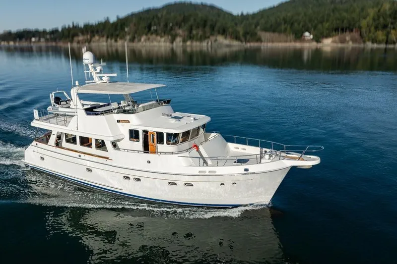 Raindancer Yacht Photos Pics 2009 Selene 60 Ocean Trawler cruising on calm waters with scenic forested background.
