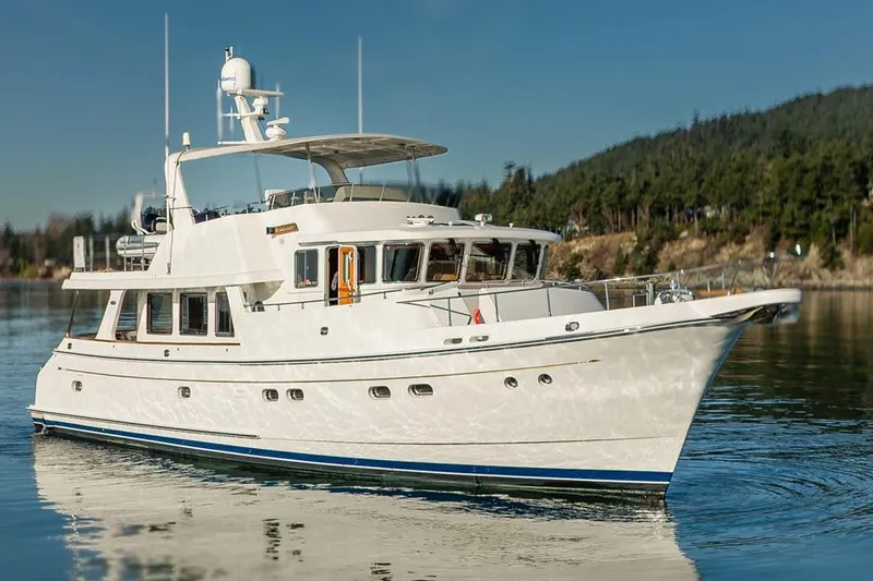 Raindancer Yacht Photos Pics 2009 Selene 60 Ocean Trawler yacht cruising on calm waters with scenic forest backdrop.