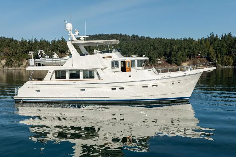 Raindancer Yacht Photos Pics 2009 Selene 60 Ocean Trawler yacht on calm water with forested shoreline.