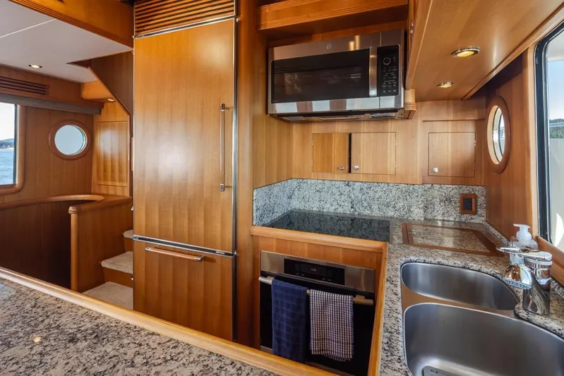 Raindancer Yacht Photos Pics Luxurious 2009 Selene 60 Ocean Trawler kitchen with wood cabinetry and granite countertops.