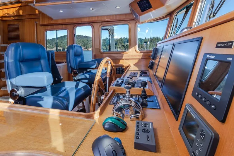 Raindancer Yacht Photos Pics Pilothouse of 2009 Selene 60 Ocean Trawler with navigation equipment and blue captain chairs.