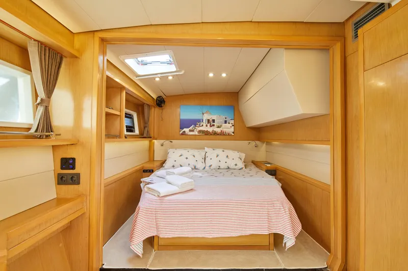  Yacht Photos Pics Luxurious cabin interior of 2014 Lagoon 52 F yacht with cozy bed and natural wood finish.