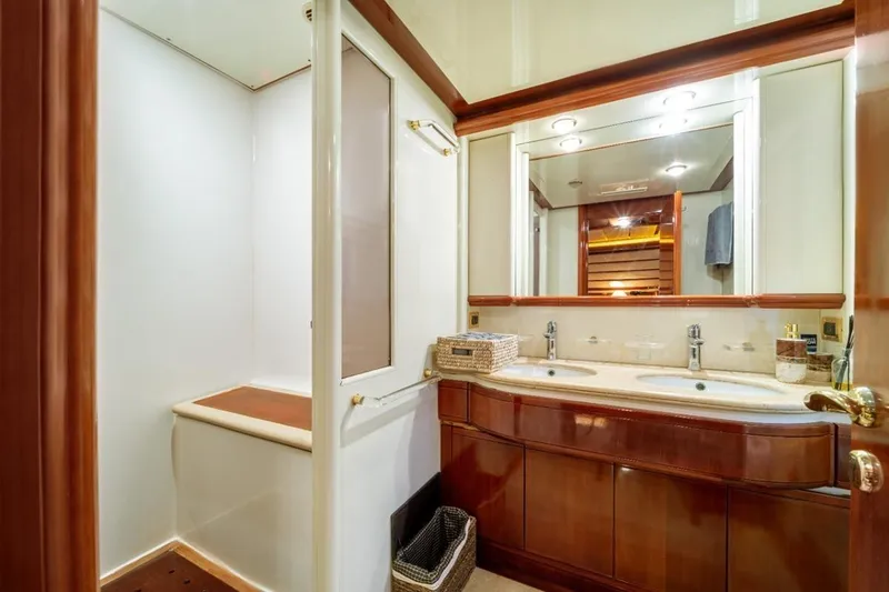  Yacht Photos Pics Luxurious bathroom in 1999 Ferretti Customline 94 yacht with double sinks and elegant wood finishes.
