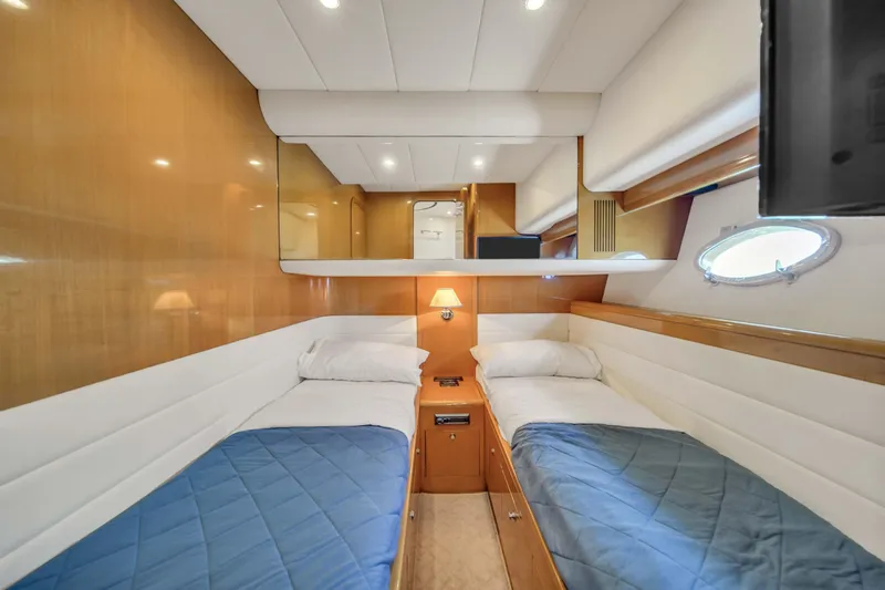  Yacht Photos Pics Twin cabin interior of 2006 Uniesse 58 yacht with wood paneling and blue bedding.