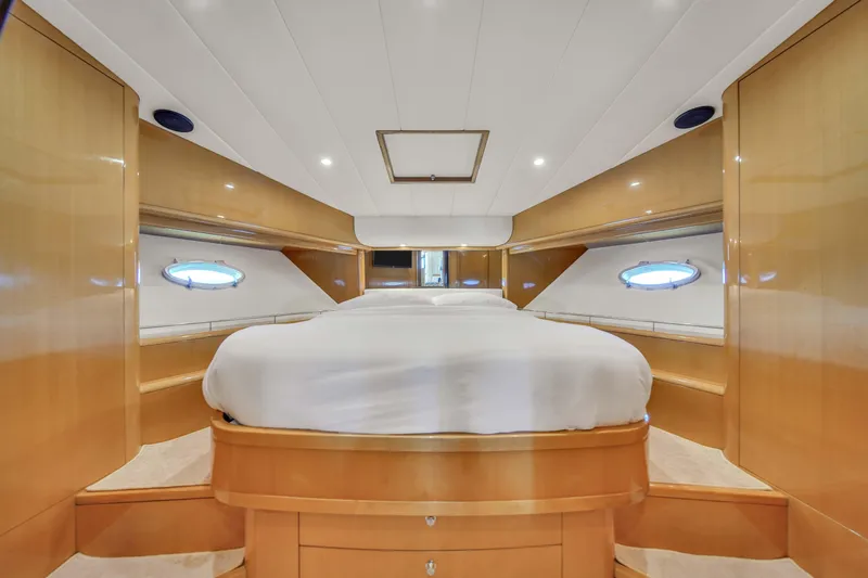  Yacht Photos Pics Luxurious master cabin in a 2006 Uniesse 58 yacht with wood paneling and porthole windows.